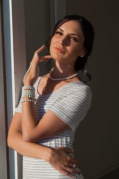 brunette woman in a striped gray white dress