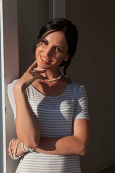 brunette woman in a striped gray white dress