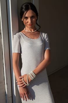 brunette woman in a striped gray white dress