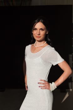 brunette woman in a striped gray white dress