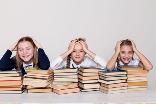 three girls in shock at school with lots of books