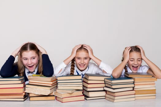 three girls in shock at school with lots of books