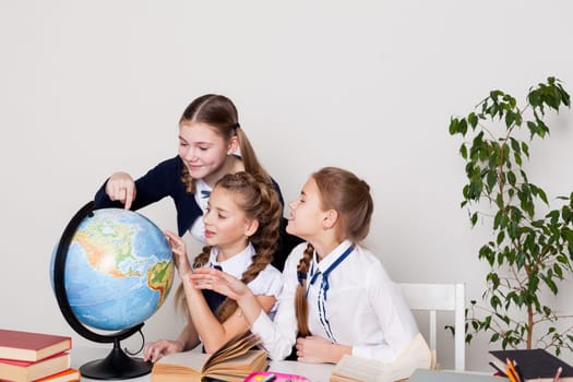 girls watching the globe in geography class