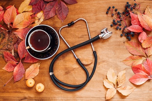 colorful leaves wooden background medical stethoscope