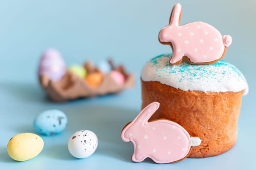 Easter still life with gingerbread in the form of a rabbit on an Easter cake, small decorative multicolored eggs lie next to it.
