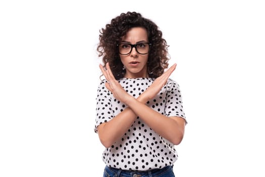young confident leader woman with curly hairstyle dressed in summer blouse crossed her arms in front of her in disagreement.