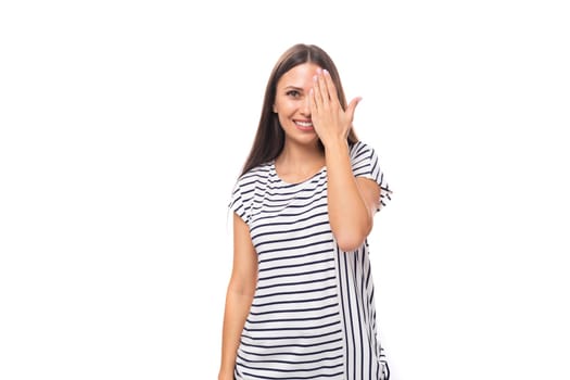 young positive pretty european brunette woman in a striped t-shirt on a white background with copy space.