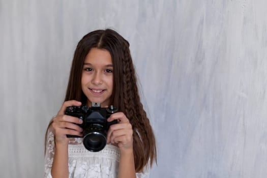 Portrait of a fashionable schoolgirl photographer girl with a camera