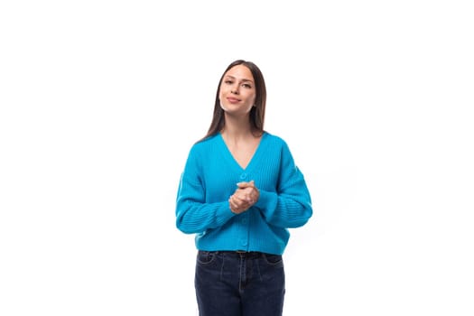pretty young brunette woman dressed in a blue v-neck cardigan.