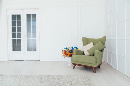 green chair in the interior of an empty white room