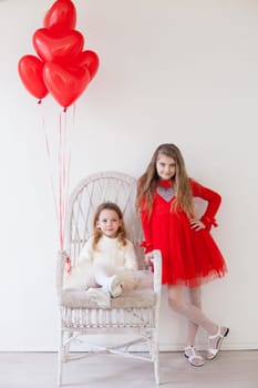 Kids with red balloons for birthday in the white room