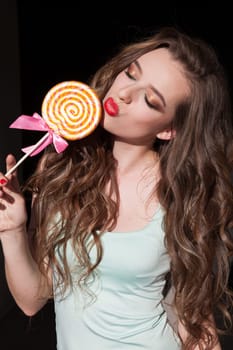 Beautiful woman eats a candy sweet lollipop