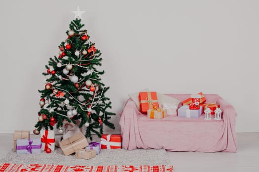 Christmas tree in a white room with Christmas decorations and gifts toys winter