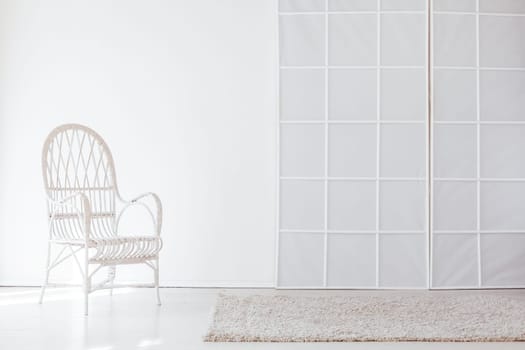 white chair in the interior of an empty white room