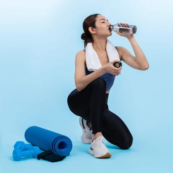 Athletic and sporty asian woman resting and drink water after intensive cardio workout training. Healthy exercising and fit body care lifestyle pursuit in studio shot isolated background. Vigorous