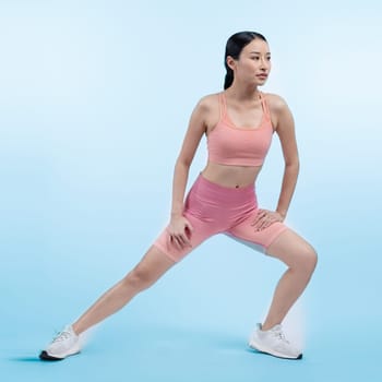 Young attractive asian woman in sportswear stretching before fitness exercise routine. Healthy body care workout with athletic woman warming up on studio shot isolated background. Vigorous