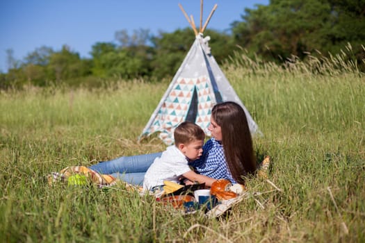 Mom and son eat on a picnic in the woods