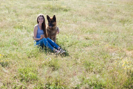 Woman trains trained sheepdog in field