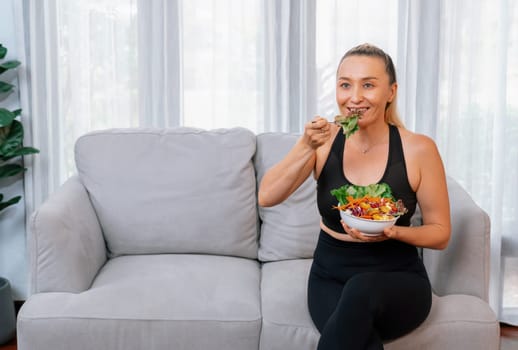 Healthy senior woman in sportswear holding a bowl of fruit and vegetable. Vegan lifestyle and healthy cuisine nutrition for fitness body physique concept. Clout