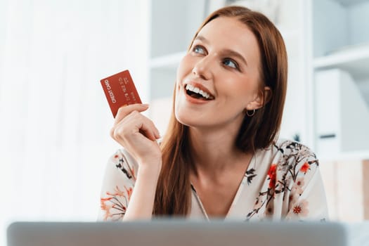 Young happy woman buy product by online shopping at home while ordering items from the internet with credit card online payment system protected by utmost cyber security from online store platform