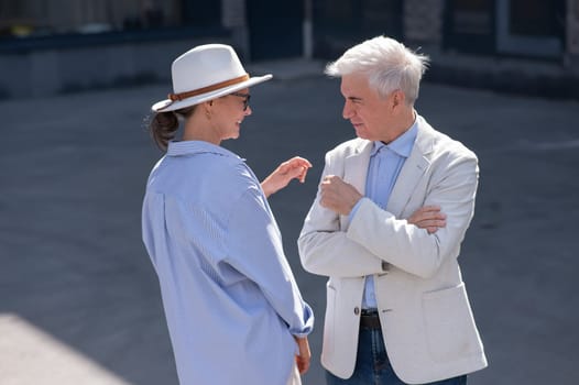 Stylish elderly laughing couple on a walk. Romantic relationships of mature people