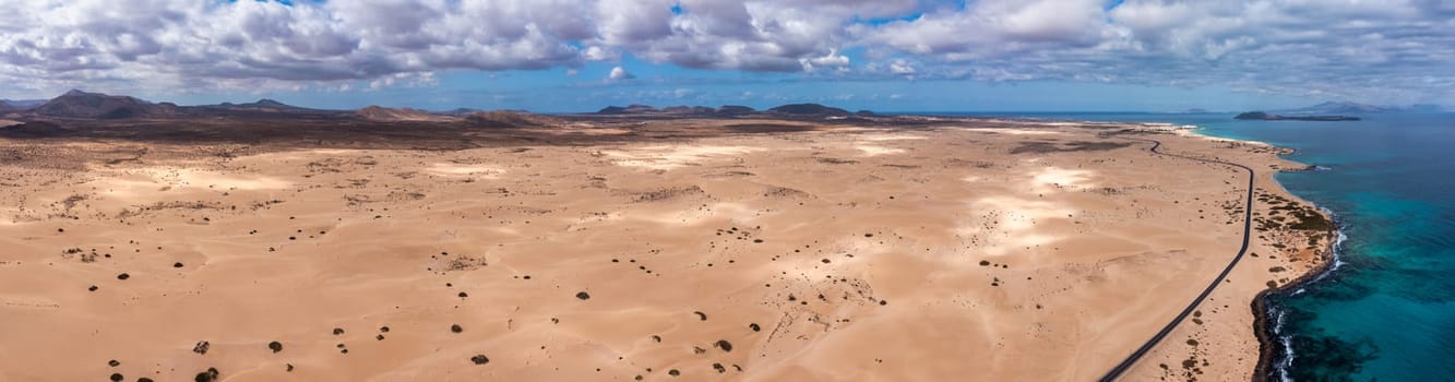 Panoramic high angle aerial drone view of Corralejo National Park (Parque Natural de Corralejo) with sand dunes located in the northeast corner of the island of Fuerteventura, Canary Islands, Spain.