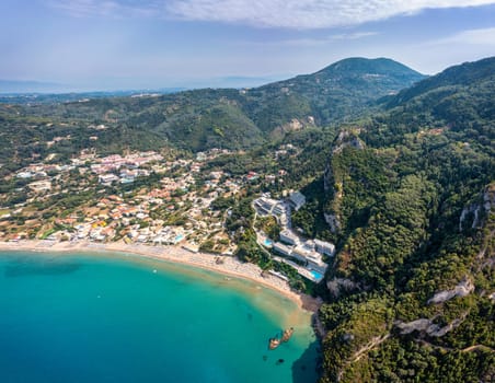 Agios Gordios exotic beach in Corfu island,Greece. Agios Gordios beach, Corfu island, Greece. Panoramic view of the Agios Gordios beach, sandy seashore with beach umbrellas and deck chairs.