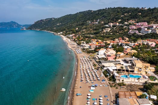 Agios Gordios exotic beach in Corfu island,Greece. Agios Gordios beach, Corfu island, Greece. Panoramic view of the Agios Gordios beach, sandy seashore with beach umbrellas and deck chairs.