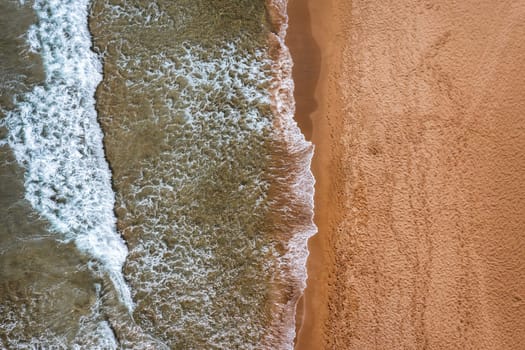 Concept of summer vacation. View from above, stunning aerial view of an amazing beach with beach umbrellas and turquoise clear water. Top view on a sun lounger under an umbrella on the sandy beach