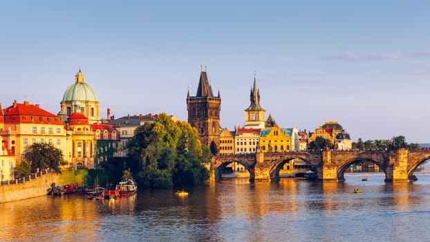Scenic view of the Old Town pier architecture and Charles Bridge over Vltava river in Prague, Czech Republic. Prague iconic Charles Bridge (Karluv Most) and Old Town Bridge Tower at sunset, Czechia.