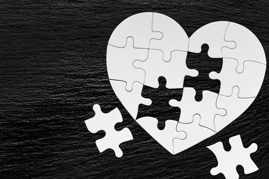 Heart object made of puzzle pieces. Make complete heart. Jigsaw puzzle pieces in form of heart. Happy Valentines Day, greeting card template. Heart jigsaw puzzle.
