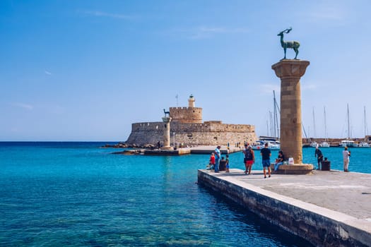 Mandraki port with deers statue, where The Colossus was standing and fort of St. Nicholas. Rhodes, Greece. Hirschkuh statue in the place of the Colossus of Rhodes, Rhodes, Greece