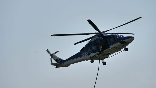 Police helicopter on aerial duty, with a clear sky backdrop, ideal for law enforcement themes, with copy space.
