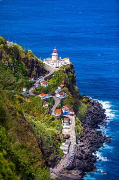 Dramatic view down to lighthouse on Ponta do Arnel, Nordeste, Sao Miguel Island, Azores, Portugal. Lighthouse Arnel near Nordeste on Sao Miguel Island, Azores, Portugal. 