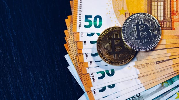 Golden bitcoin over Euro money. Bitcoin cryptocurrency. Crypto currency concept. Bitcoin with euro bills. Bitcoins stacked on euro banknotes.