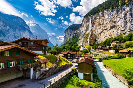 Lauterbrunnen valley with famous church and Staubbach waterfall. Lauterbrunnen village, Berner Oberland, Switzerland, Europe. Spectacular view of Lauterbrunnen valley in a sunny day, Switzerland.