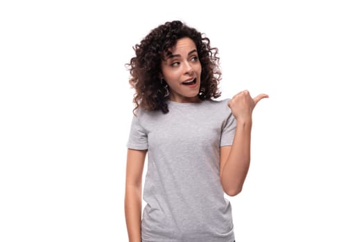 charming curly brunette promoter woman dressed in gray t-shirt with mockup for print on white background.
