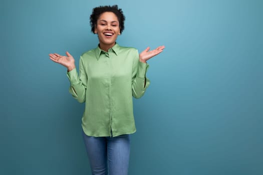 young bright cheerful latin woman dressed in a green blouse on the background with copy space.