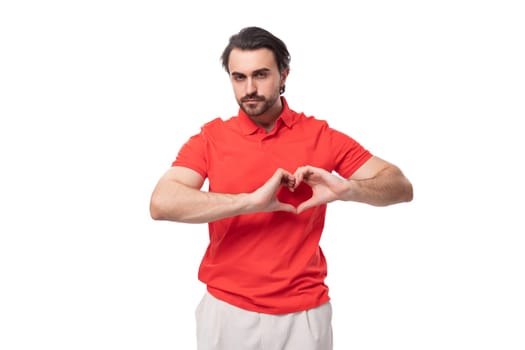 young pleasant friendly man with black hair and beard dressed in a red t-shirt on a white background with copy space.