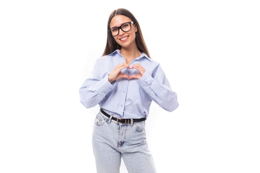 attractive well-groomed young brunette caucasian woman in glasses is dressed in a sky blue shirt on a white background with copy space.