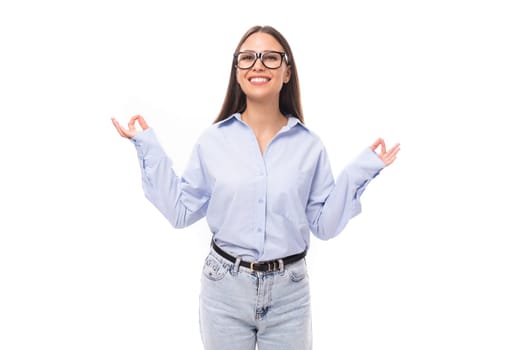 young pretty european brunette business woman with light makeup in a light blue blouse wears glasses for an image to work on a white background with copy space.