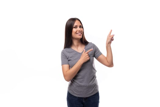 young brunette lady dressed in a gray basic t-shirt with a mockup for a logo on a white background. corporate color.