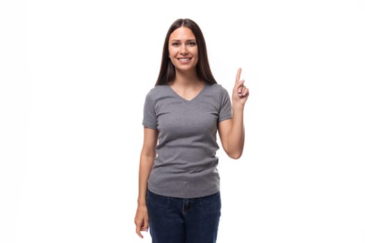 young funny cheerful caucasian woman with dark straight hair dressed in casual gray t-shirt.