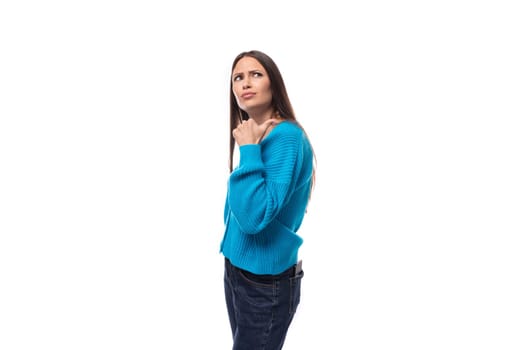 dreamy stylish young brunette lady dressed in blue casual button up cardigan on white background with copy space.