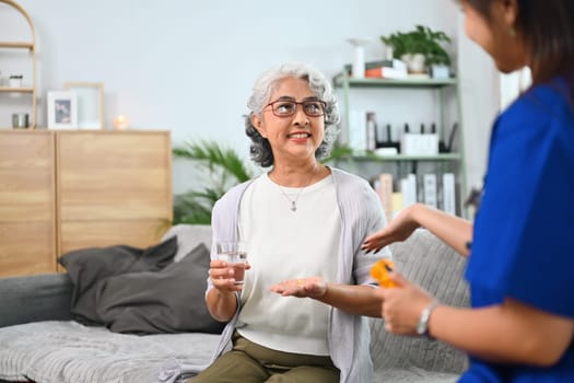 Health visitor explaining medicine dosage to mature woman. Home health care service concept.