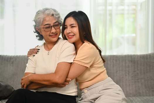 Loving young Asian woman hugging happy mature mother. International hug day concept.