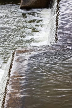 The flow of water in the city waterfall close up