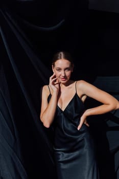 fashionable slender woman in black silk evening dress