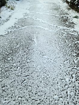Snow on asphalt on a small german road.