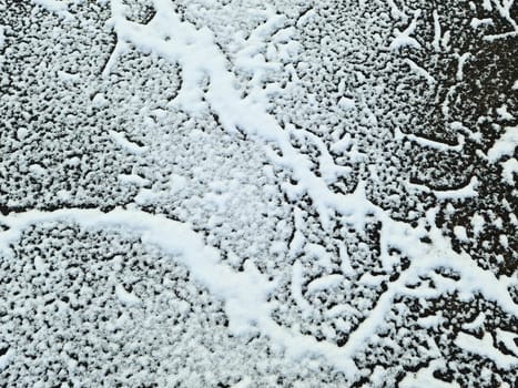 Snow on asphalt on a small german road.